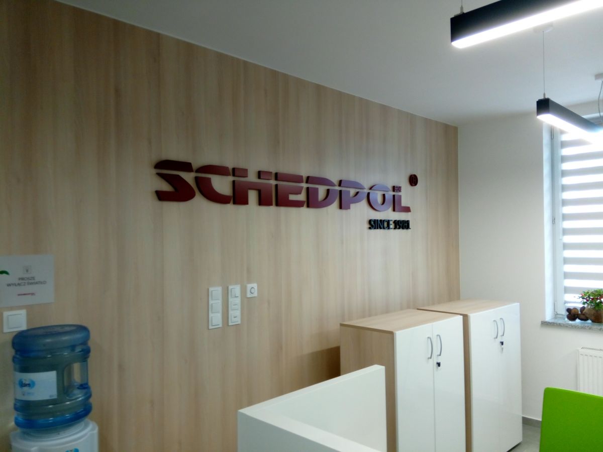 Logo przestrzenne na ścianie w budynku dewelopera.